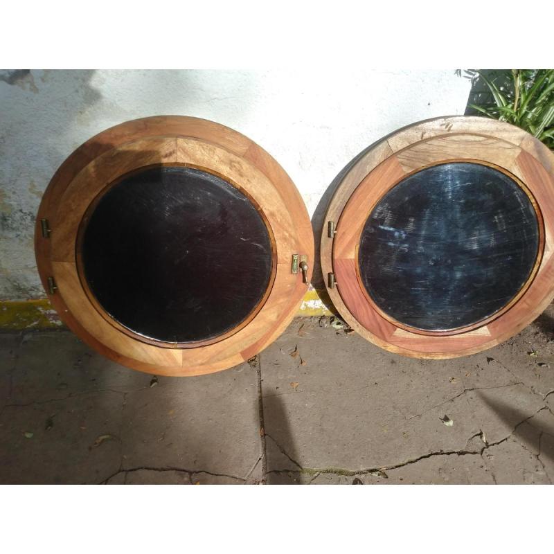 Dos ojos de buey de cedro con vidrio ,mosquiteros ,herrajes.